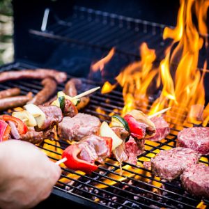 Detail Of Beef Burgers and sausages Cooking On A Barbecue